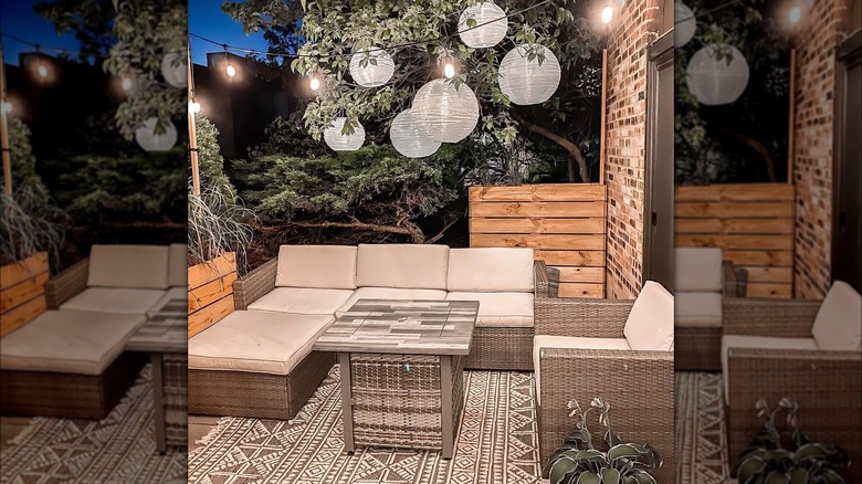 String lights and paper lanterns on patio with furniture