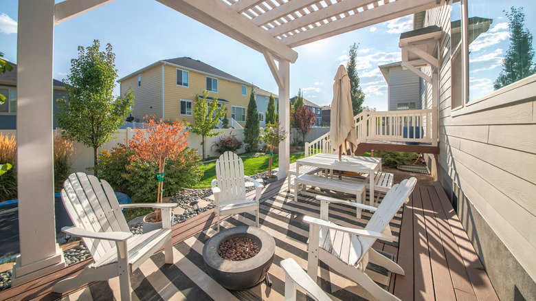 Fire pit in the midst of white chairs on patio