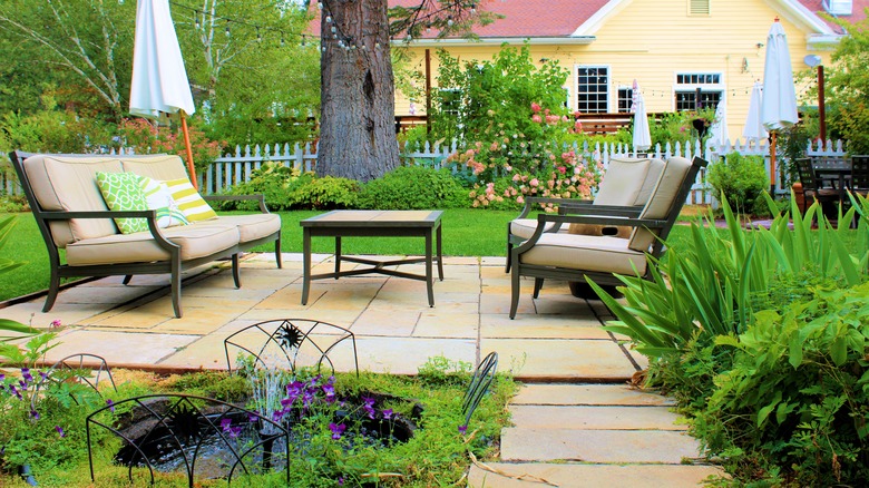 Patio seating surrounded by beautiful plants and flowers