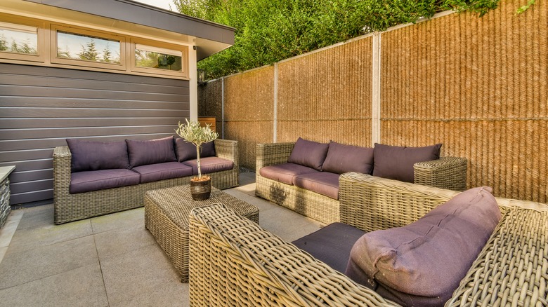 Wicker furniture with purple couch cushions on patio