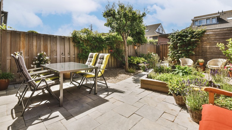 Chairs, table, and plant pots on a paver patio