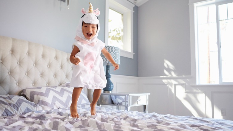 Girl jumping on bed