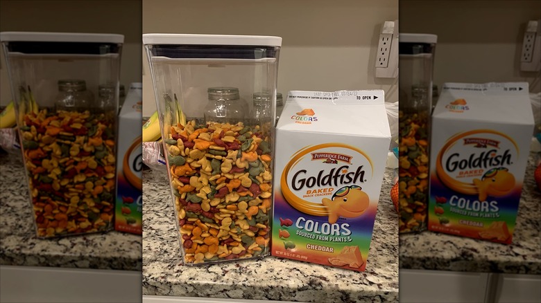 Colorful Goldfish crackers are stored in an OXO pop top container