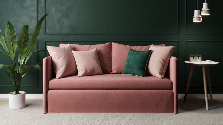 Pink velvet sofa green wall