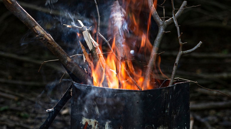 An oil can is repurposed into a fire pit for backyard relaxing.