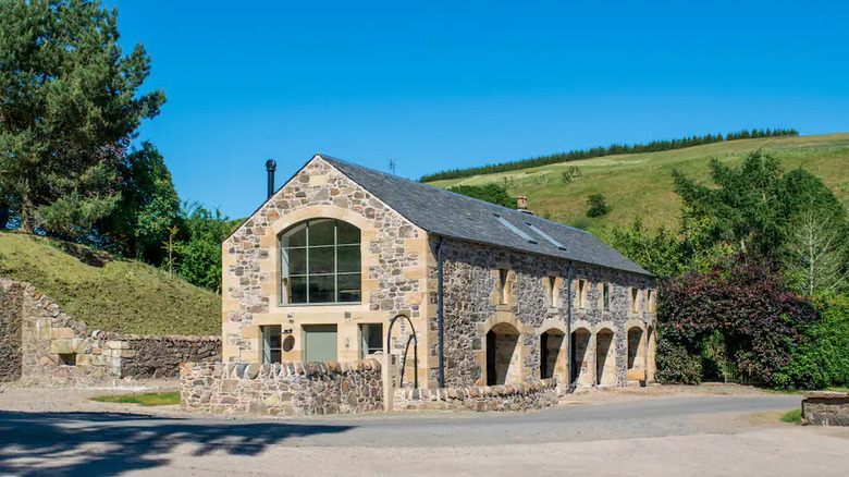 stone barn by a hill