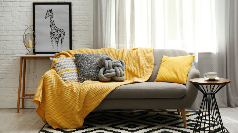 yellow blanket on gray couch