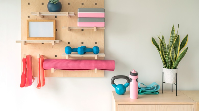 wooden pegboard with workout equipment