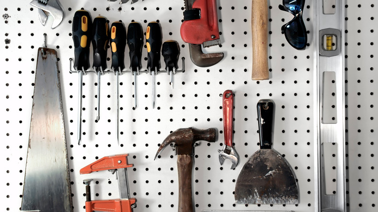 white pegboard holding tools