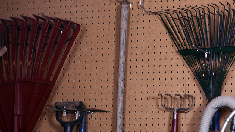 rakes and shovels on pegboard