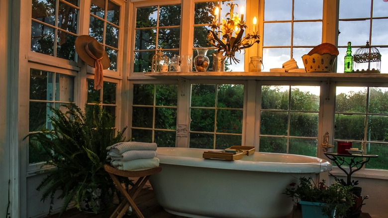 bathroom with tub and greenery