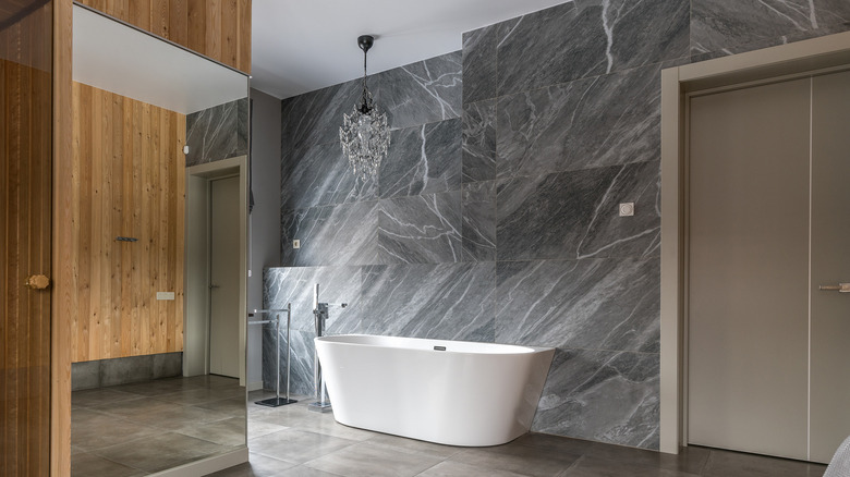 bathroom with chandelier and bathtub