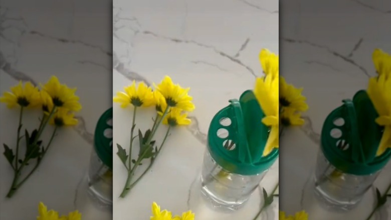 Threading fresh flowers through the lid of a parmesan cheese container.