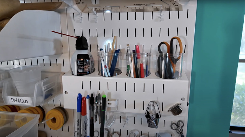 Tools used for sewing are neatly arranged in a wall organizer.