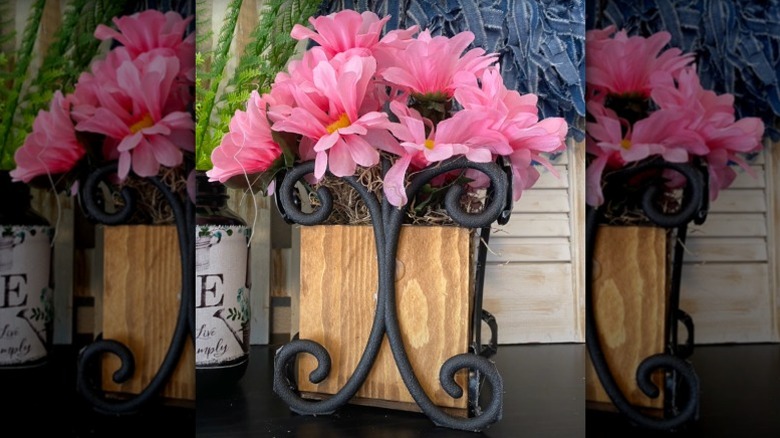 A planter stand made from a wooden box and Dollar Tree garden fence