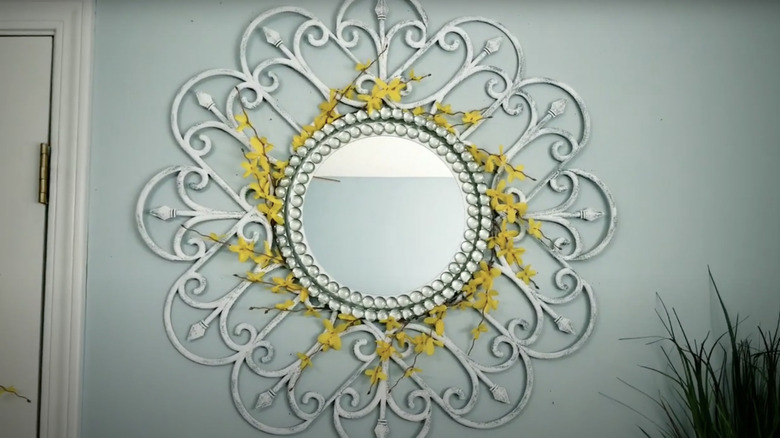 Decorative mirror made from faux flowers and Dollar Tree garden fence