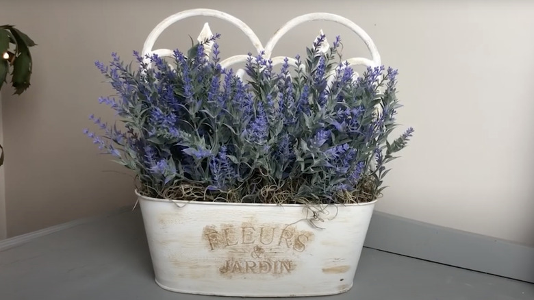 A French country style planter made from Dollar Tree fences and a steel tub filled with lavender