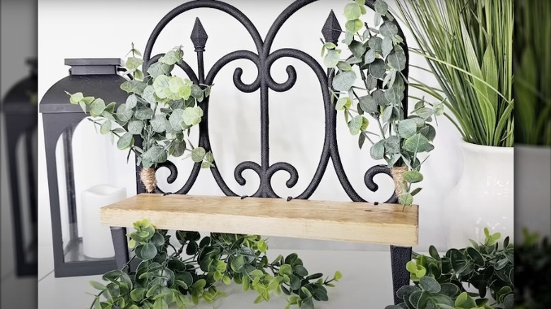 Small tabletop storage shelf made from a wooden board and Dollar Tree garden fencing