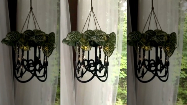 A chandelier light fixture made from Dollar Tree garden fence and faux foliage