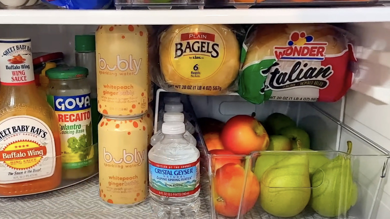 A shelf riser placed on a shelf fridge to store bread.