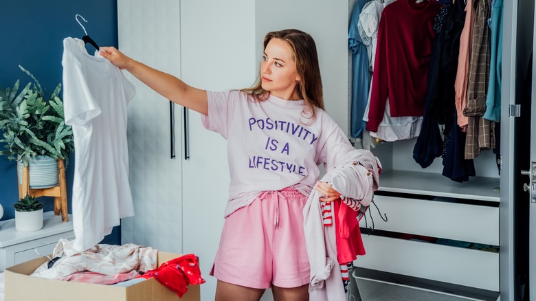 woman decluttering clothes in closet