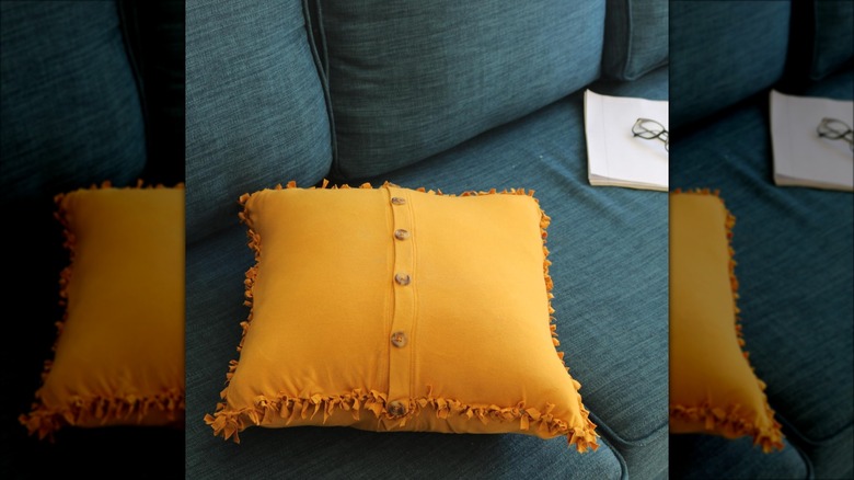 yellow throw pillow with buttons