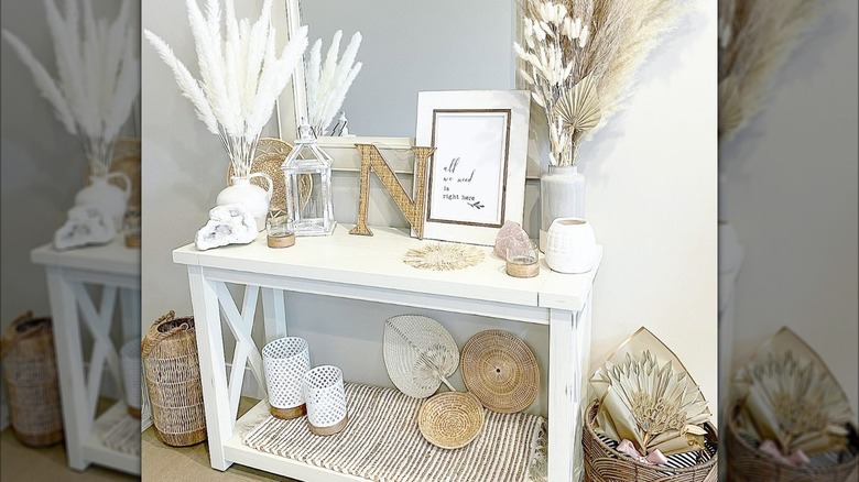 A neutral white maximalist entryway table