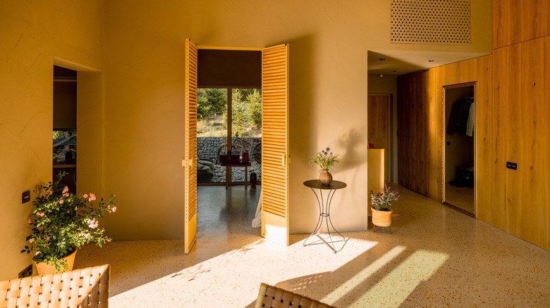 A yellow entryway with open front doors