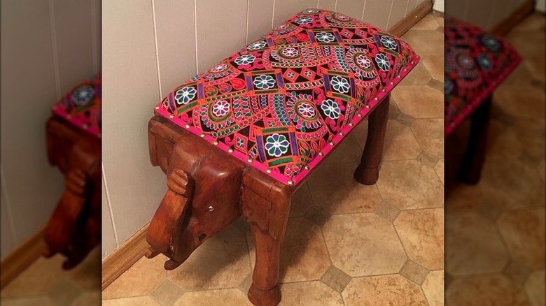 An elephant entryway bench with a colorful seat on top