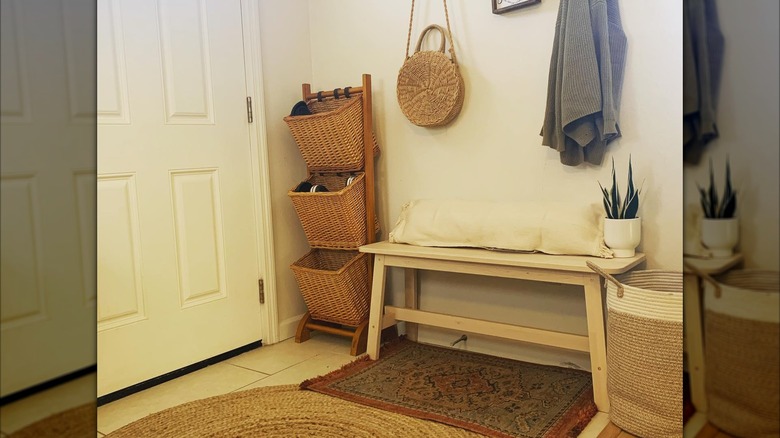 An entryway with wicker baskets, bench, and other decorations