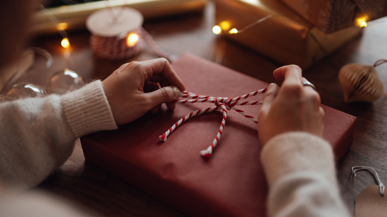 person tying ribbon on present