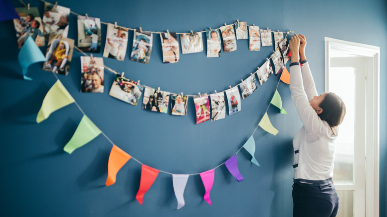 woman hanging photos on wall