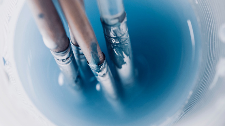 paintbrushes in plastic cup