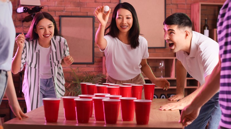 friends playing beer pong