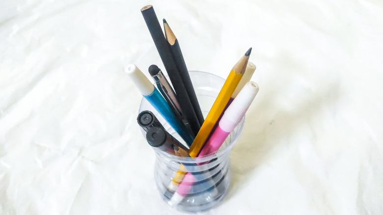 writing utensils in plastic cup