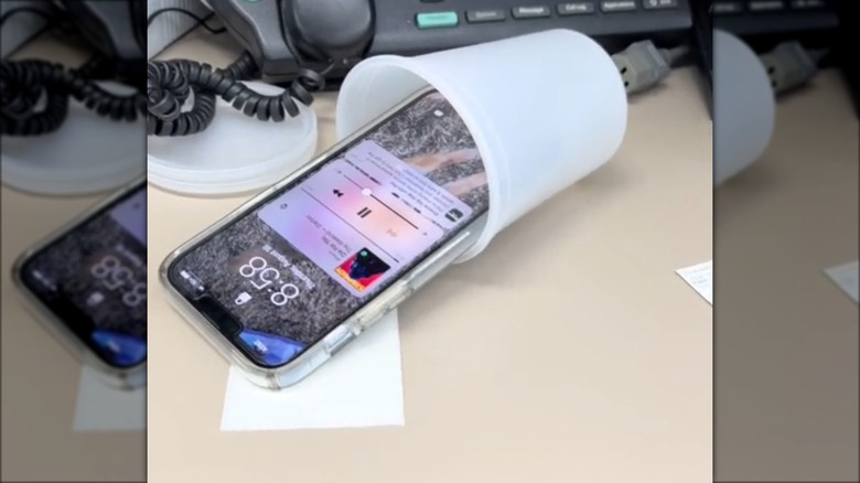 phone in plastic cup playing music