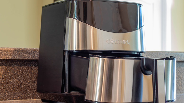 A black and gray air fryer sitting on kitchen countertop