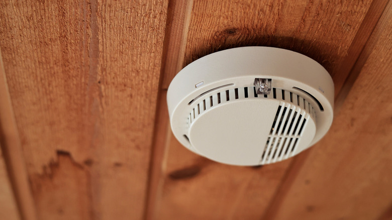 White smoke alarm on wooden background