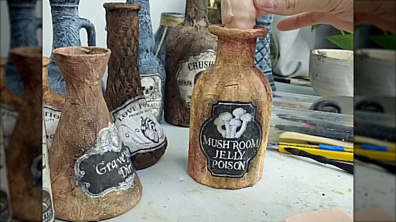 Old vinegar bottles turned into spooky fake witch potion bottles for Halloween.