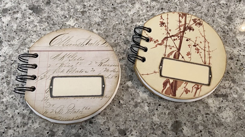 Two mini notebooks with covers made from old paper coasters.