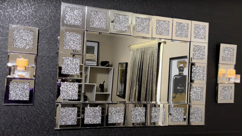 A wall mirror framed with glittery mirror glass coasters.