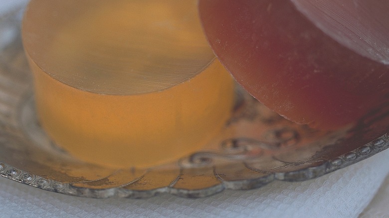 Bars of glycerine soap sit on a repurposed decorative drinks coaster.