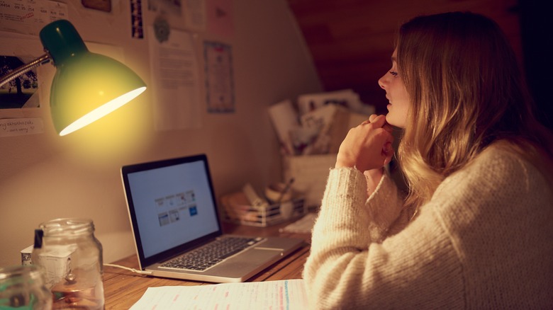 woman working at desk with lamp