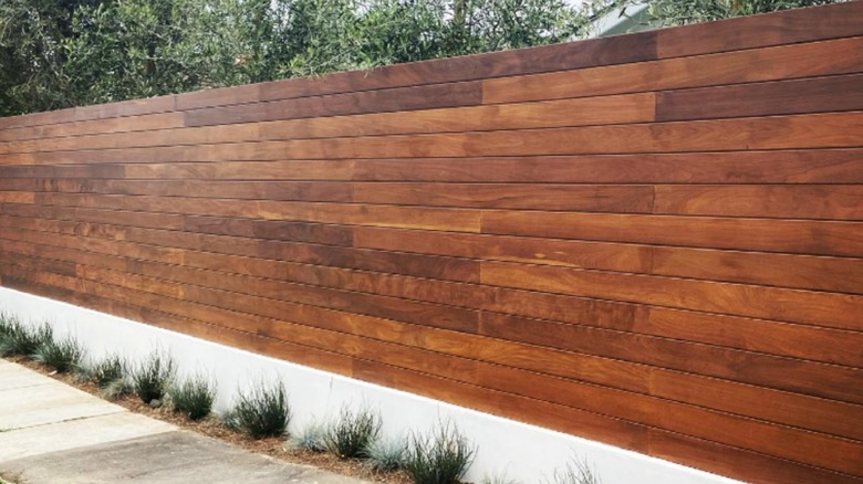 Solid wood horizontal fence on retaining wall