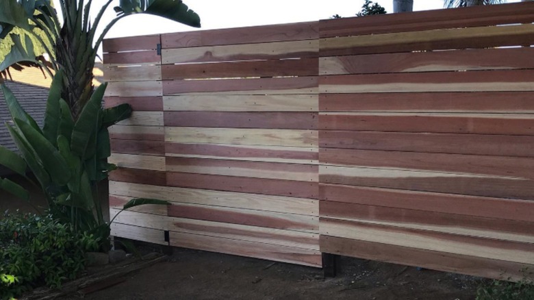 Wood fence with varying finish horizontal slats