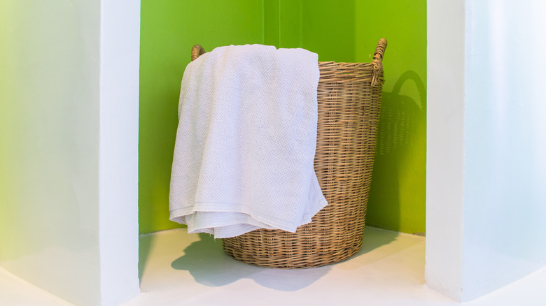 Wicker basket with white towel in a closet