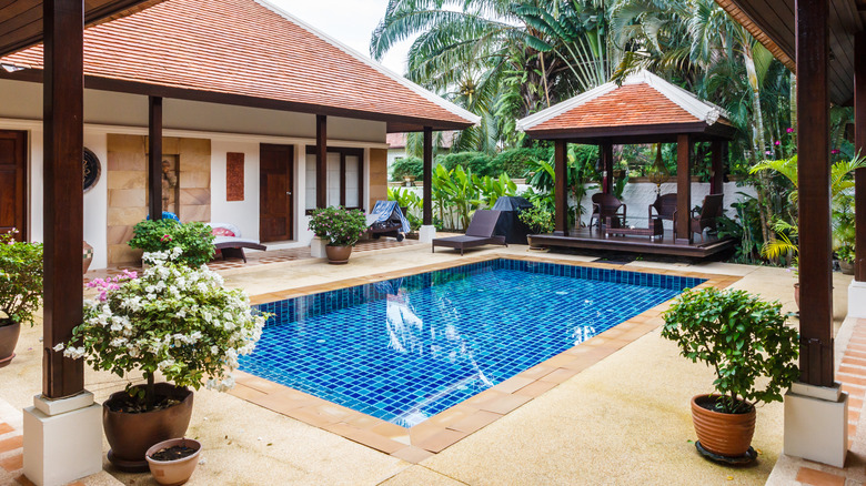 Tiny pool by wood-beamed houses