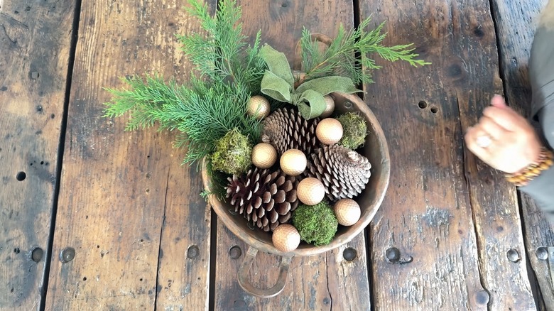 Centerpiece containing golf balls, pine cones, bows, and greenery