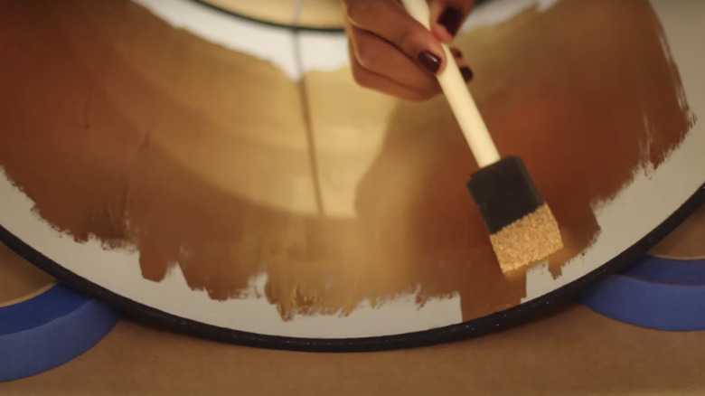 person painting gold inside lampshade