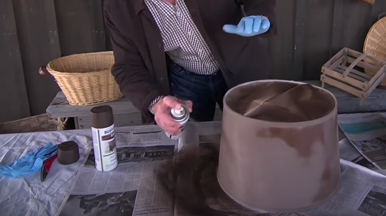 person spray painting a lampshade